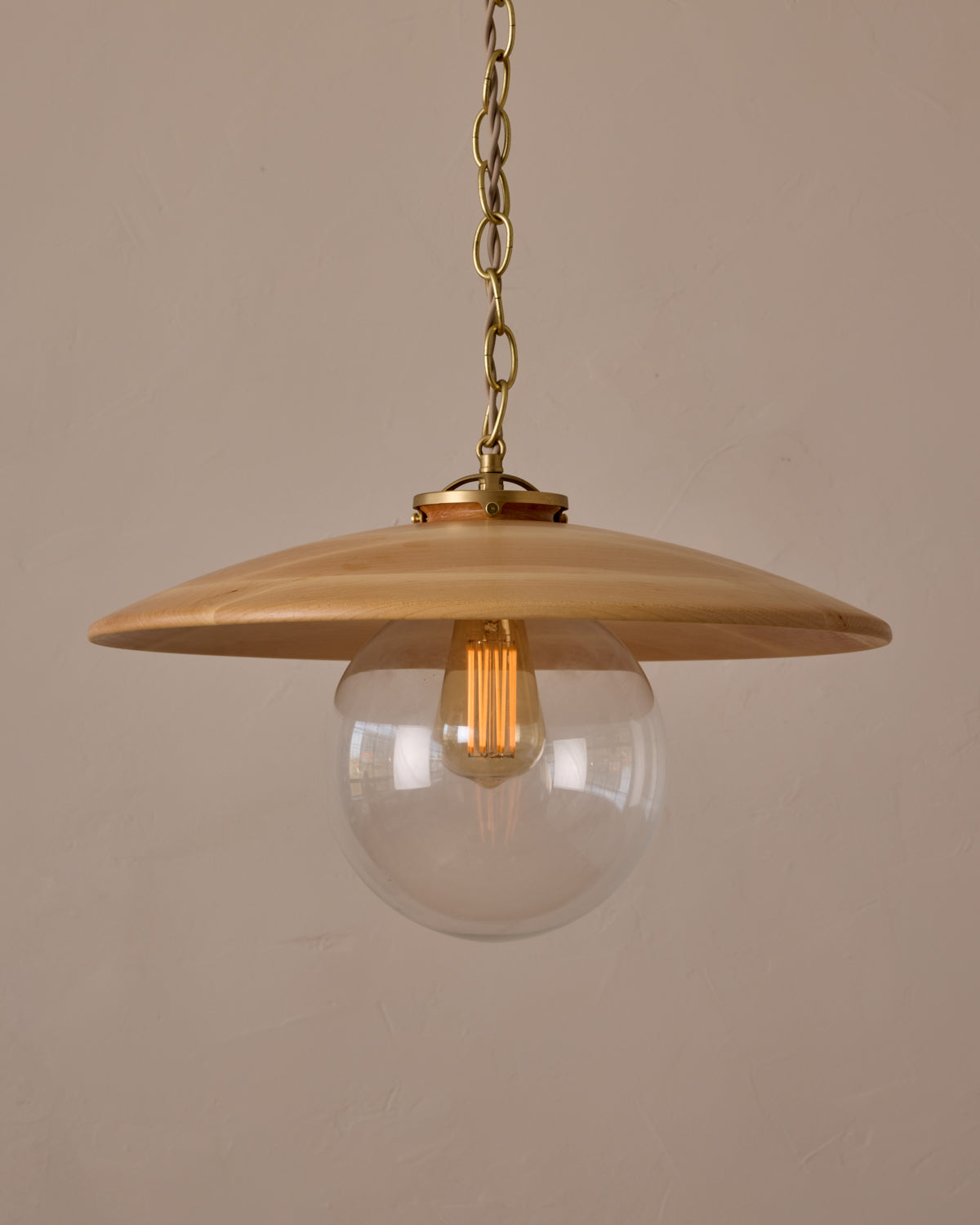 Large pendant light with oversized clear glass globe and decorative wooden clear maple shade with brass chain #shade-finish_natural maple #globe_clear glass #cord-color_beige