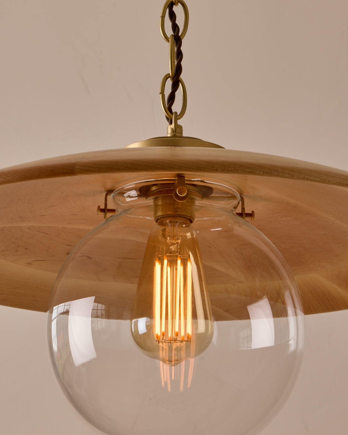 Large pendant light with oversized clear glass globe and decorative wooden clear maple shade with brass chain #shade-finish_natural maple #globe_clear glass #cord-color_brown