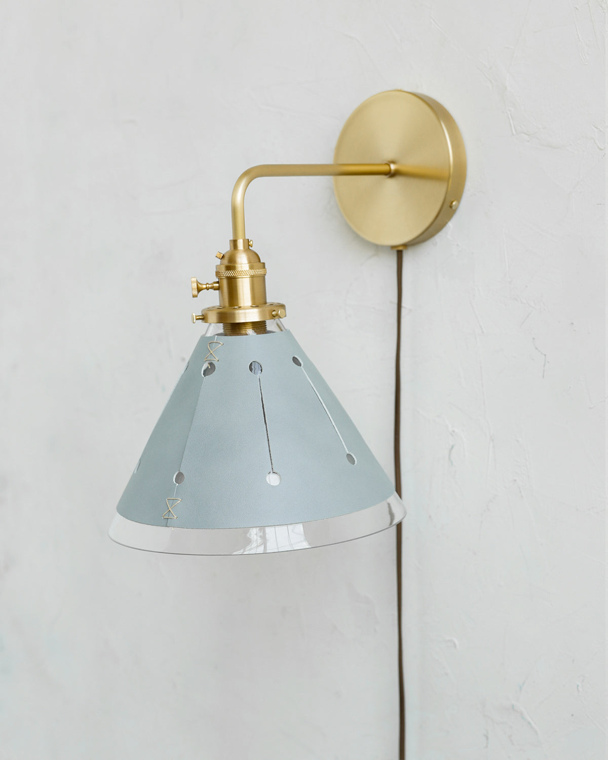 Classic satin brass plug in wall sconce with cone glass diffuser and decorative handstitched leather shade #leather-finish_cloud blue #wiring_plug-in