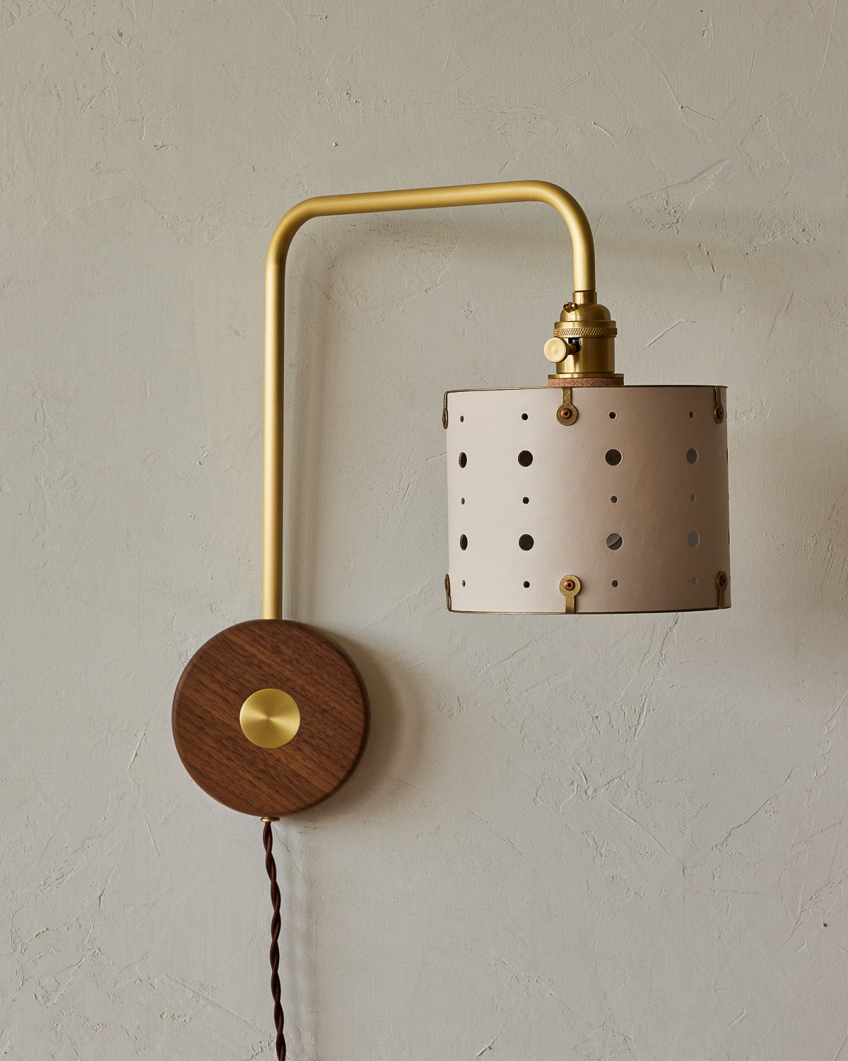 Articulating satin brass plug-in wall sconce with white handstitched shade and walnut backplate #leather-finish_dogwood #wiring_plug-in
