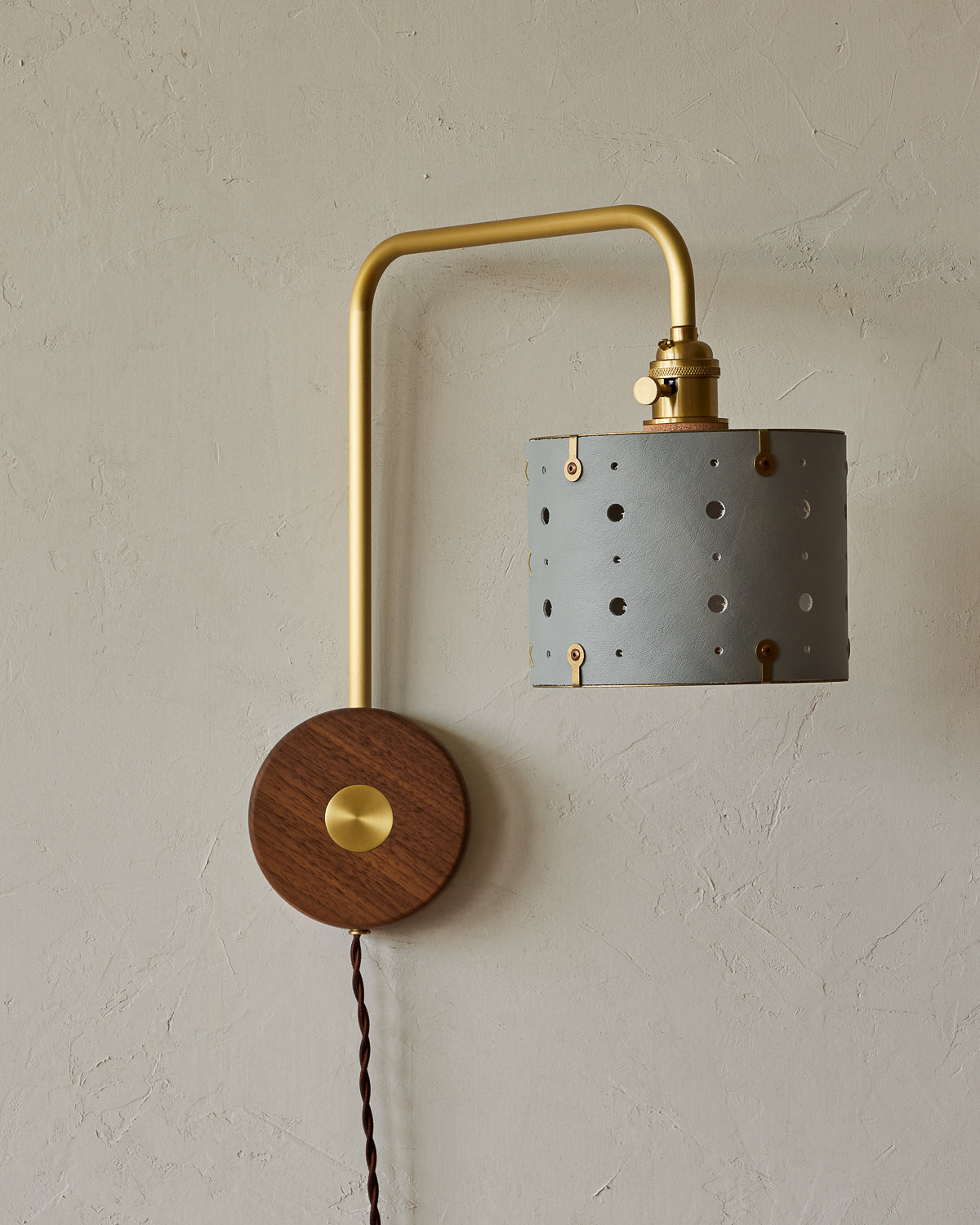 Articulating satin brass plug-in sconce with blue handstitched shade and walnut backplate #leather-finish_cloud blue #wiring_plug-in