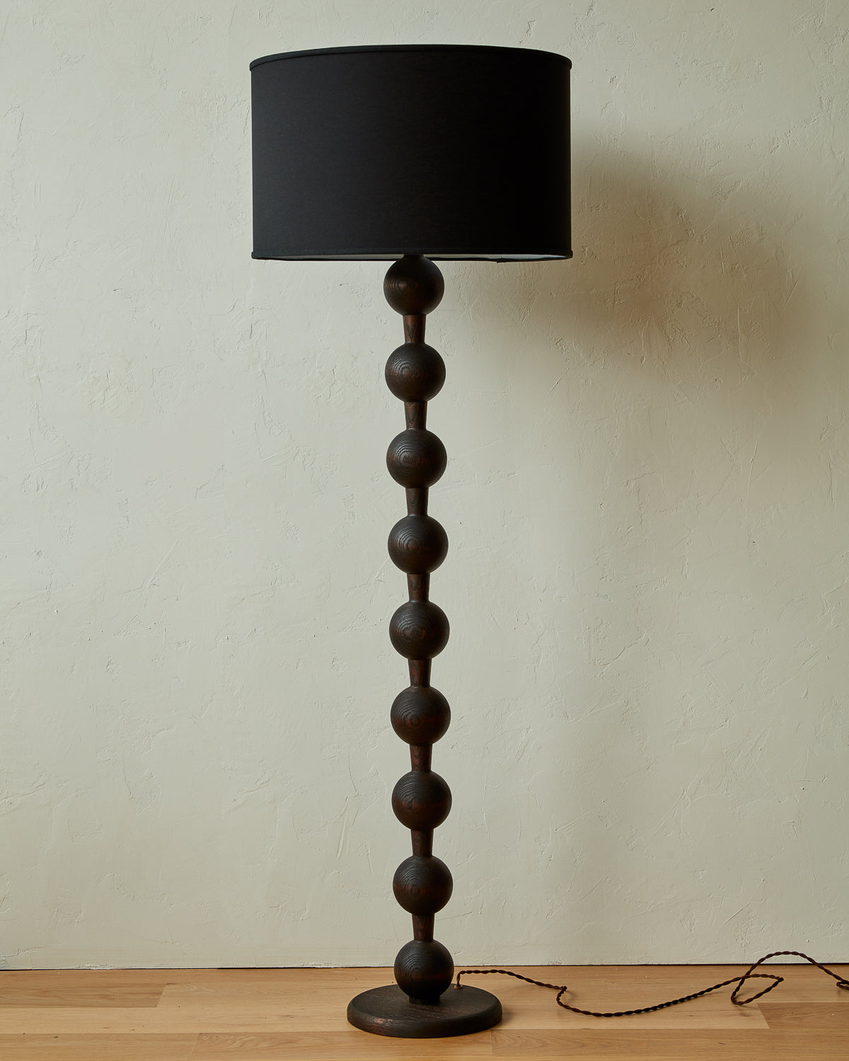Tall sculptural solid red oak floor lamp with barbell design in dark wash finish with ivory linen drum shade
#color_dark wash red oak
#shade-color_black linen