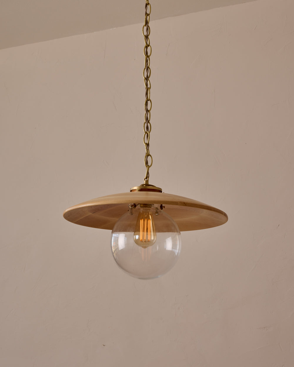 Large pendant light with oversized clear glass globe and decorative wooden clear maple shade with brass chain  #shade-finish_natural maple #globe_clear glass #cord-color_beige