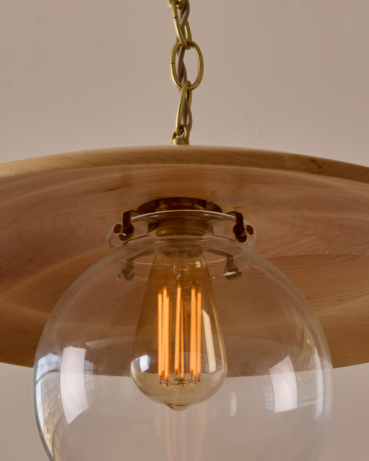 Large pendant light with oversized clear glass globe and decorative wooden clear maple shade with brass chain  #shade-finish_natural maple #globe_clear glass #cord-color_beige