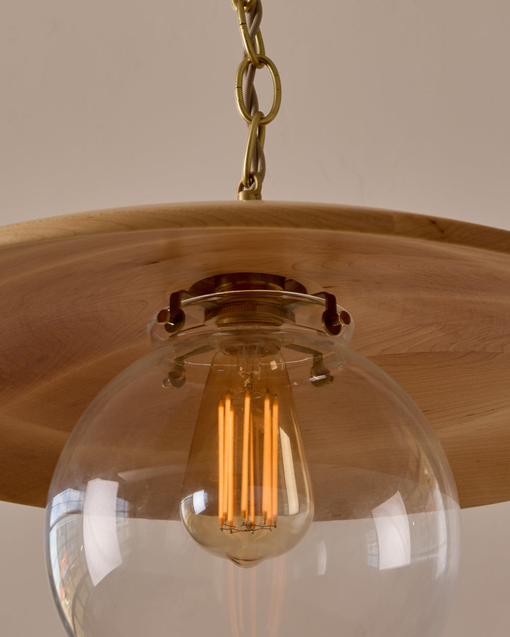 Large pendant light with oversized clear glass globe and decorative wooden clear maple shade with brass chain  #shade-finish_natural maple #globe_clear glass #cord-color_beige