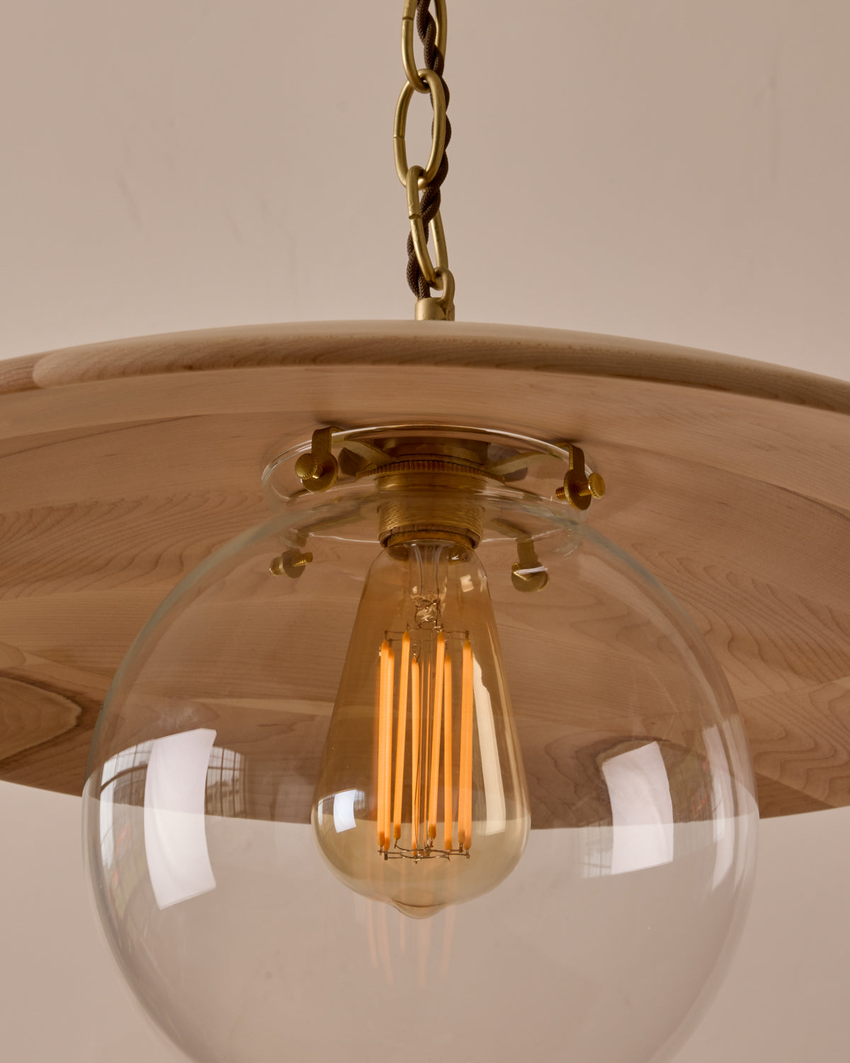 Large pendant light with oversized clear glass globe and decorative wooden clear maple shade with brass chain #shade-finish_clear maple #globe_clear glass #cord-color_brown