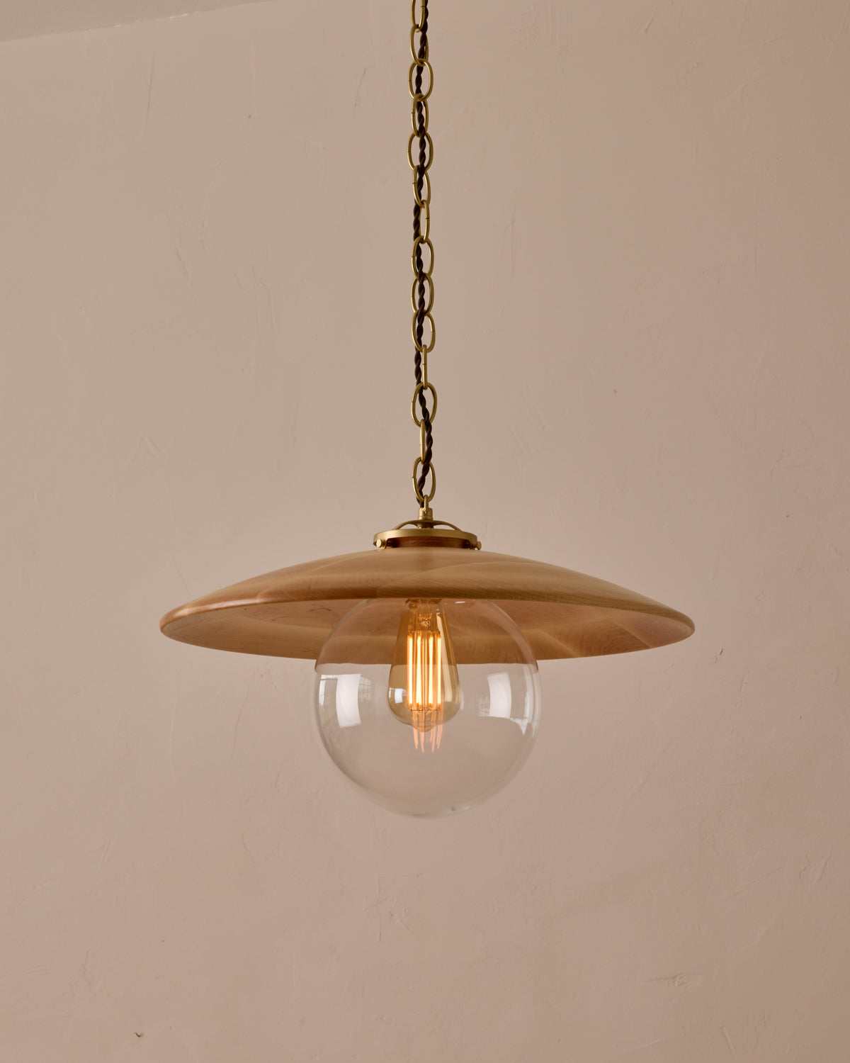 Large pendant light with oversized clear glass globe and decorative wooden clear maple shade with brass chain  #shade-finish_natural maple #globe_clear glass #cord-color_brown