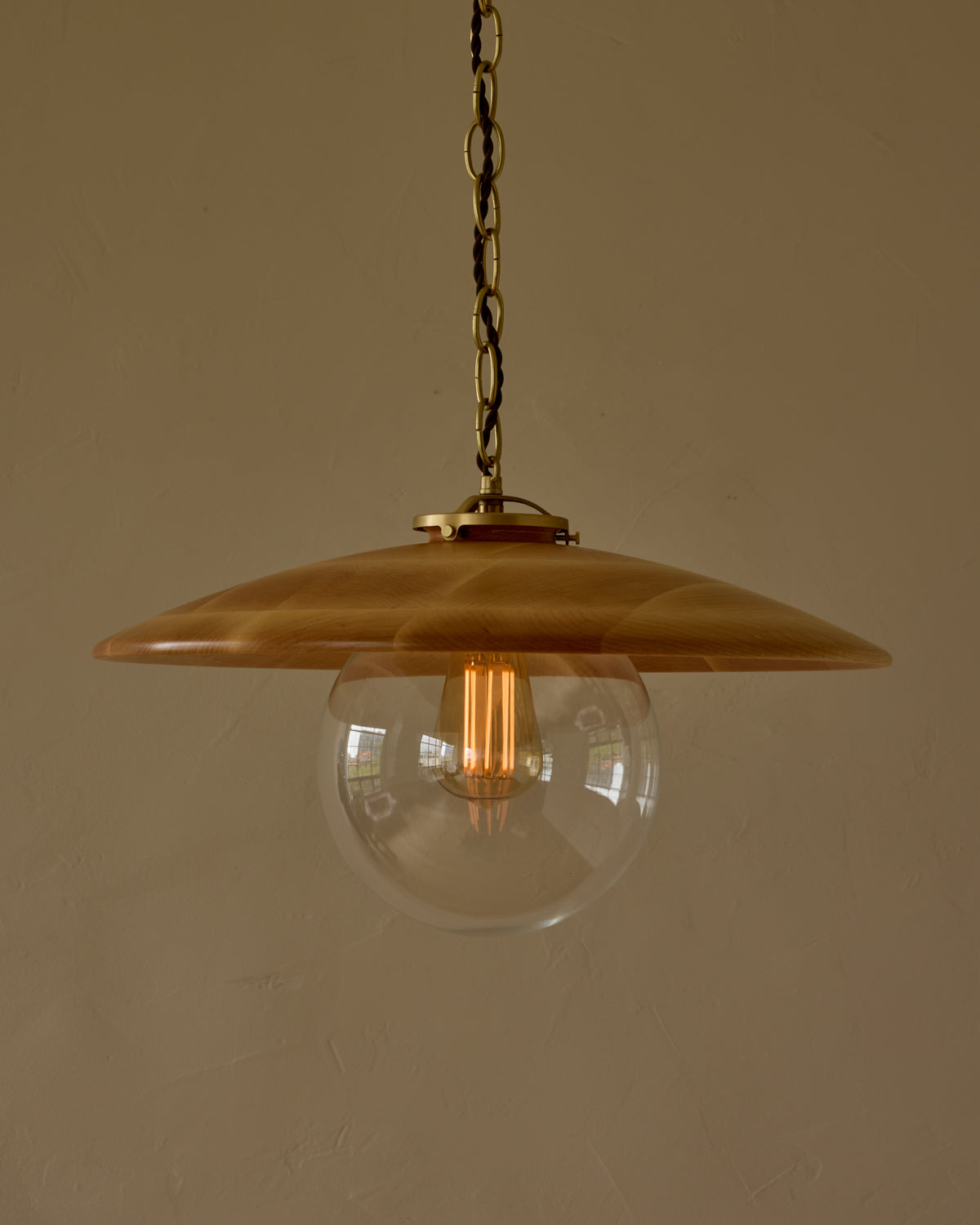 Large pendant light with oversized clear glass globe and decorative wooden clear maple shade with brass chain  #shade-finish_natural maple #globe_clear glass #cord-color_brown
