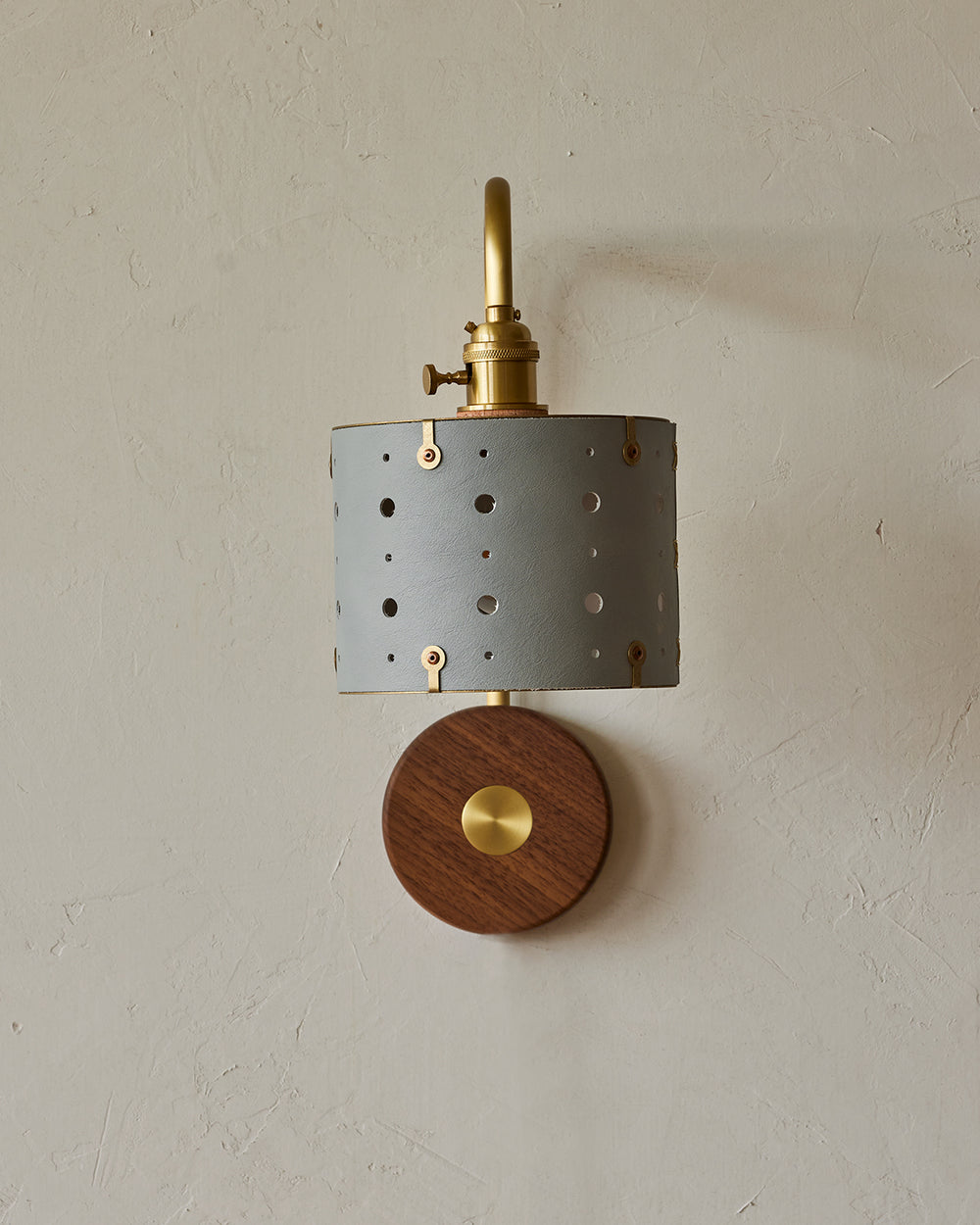 Articulating satin brass sconce with blue handstitched leather shade and walnut backplate #leather-finish_cloud blue #wiring_hardwired