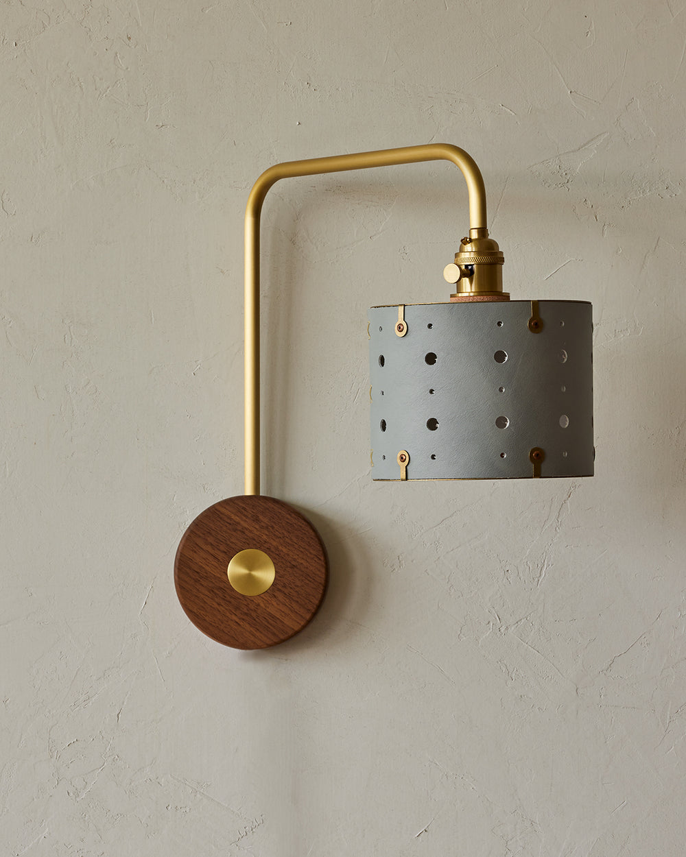 Articulating satin brass sconce with blue handstitched leather shade and walnut backplate #leather-finish_cloud blue #wiring_hardwired