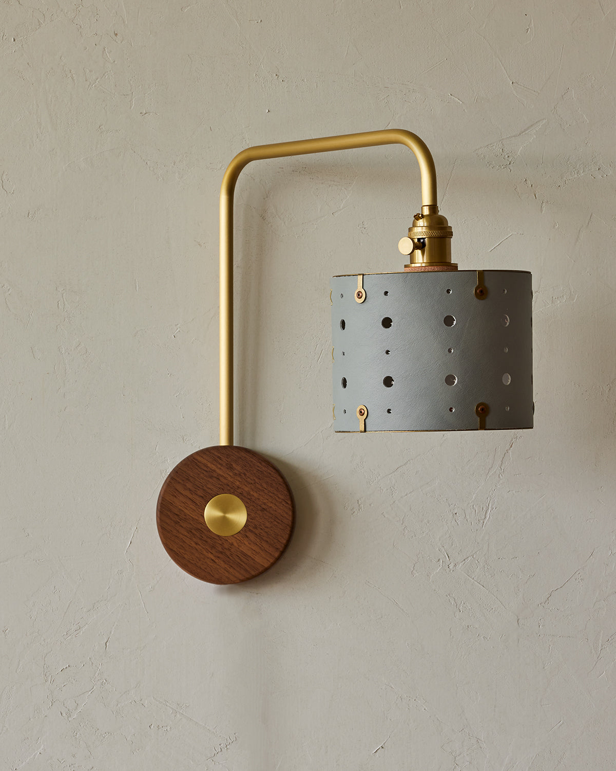 Articulating satin brass sconce with blue handstitched leather shade and walnut backplate #leather-finish_cloud blue #wiring_hardwired