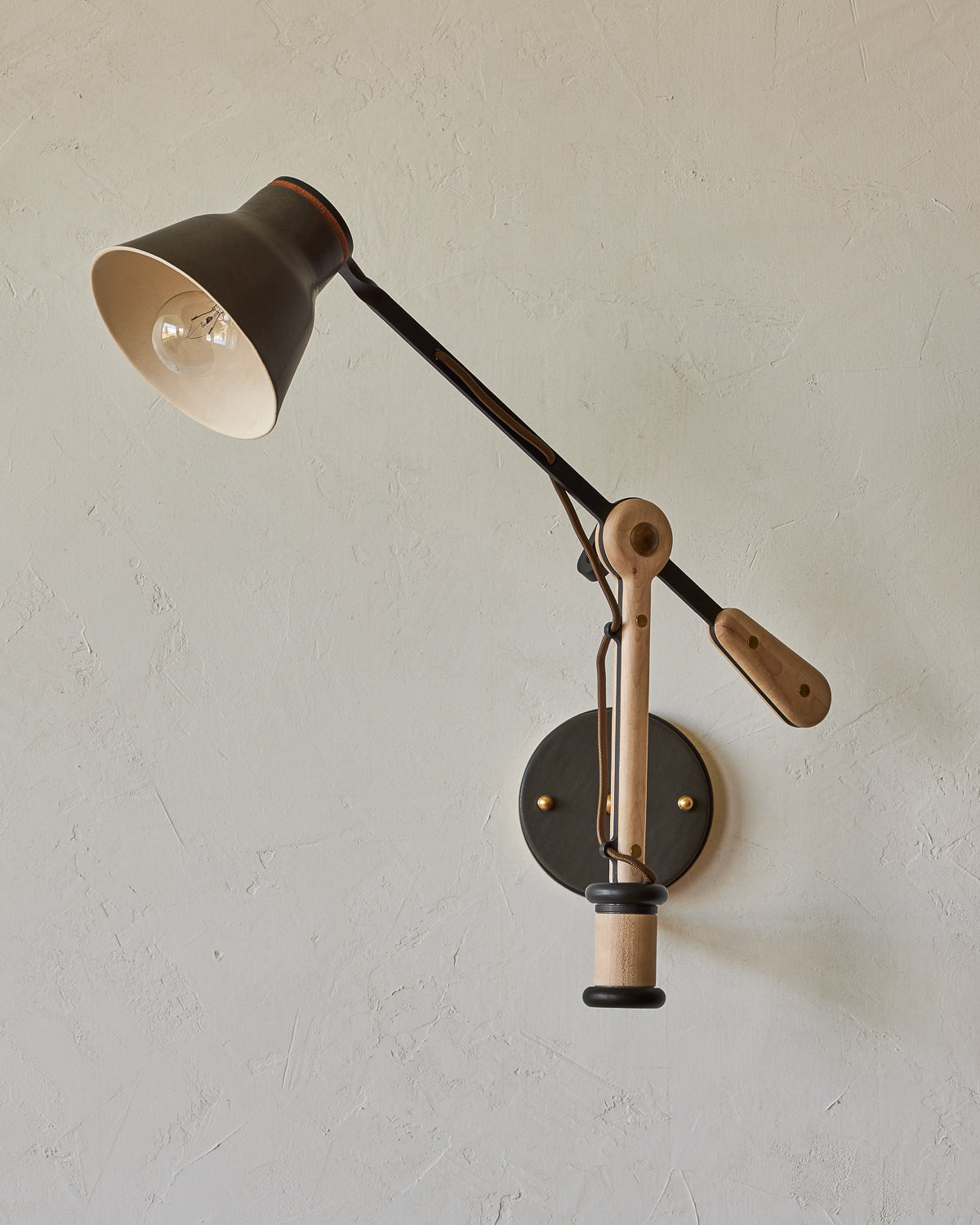 Maple, steel and ceramic wall sconce with articulating arm with matte black stoneware shade #color_almost black