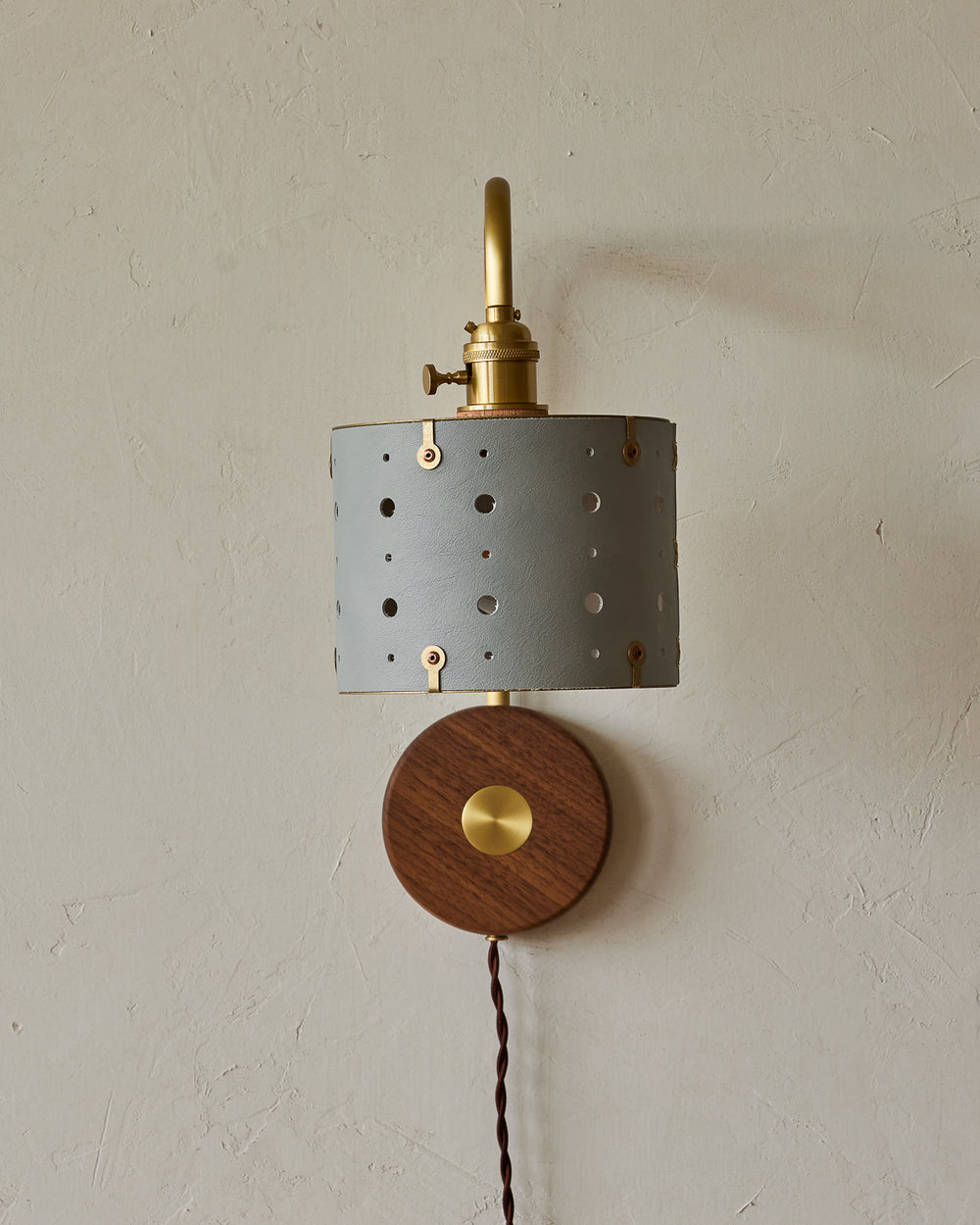 Articulating satin brass sconce with blue handstitched shade and walnut backplate  #leather-finish_cloud blue #wiring_plug-in