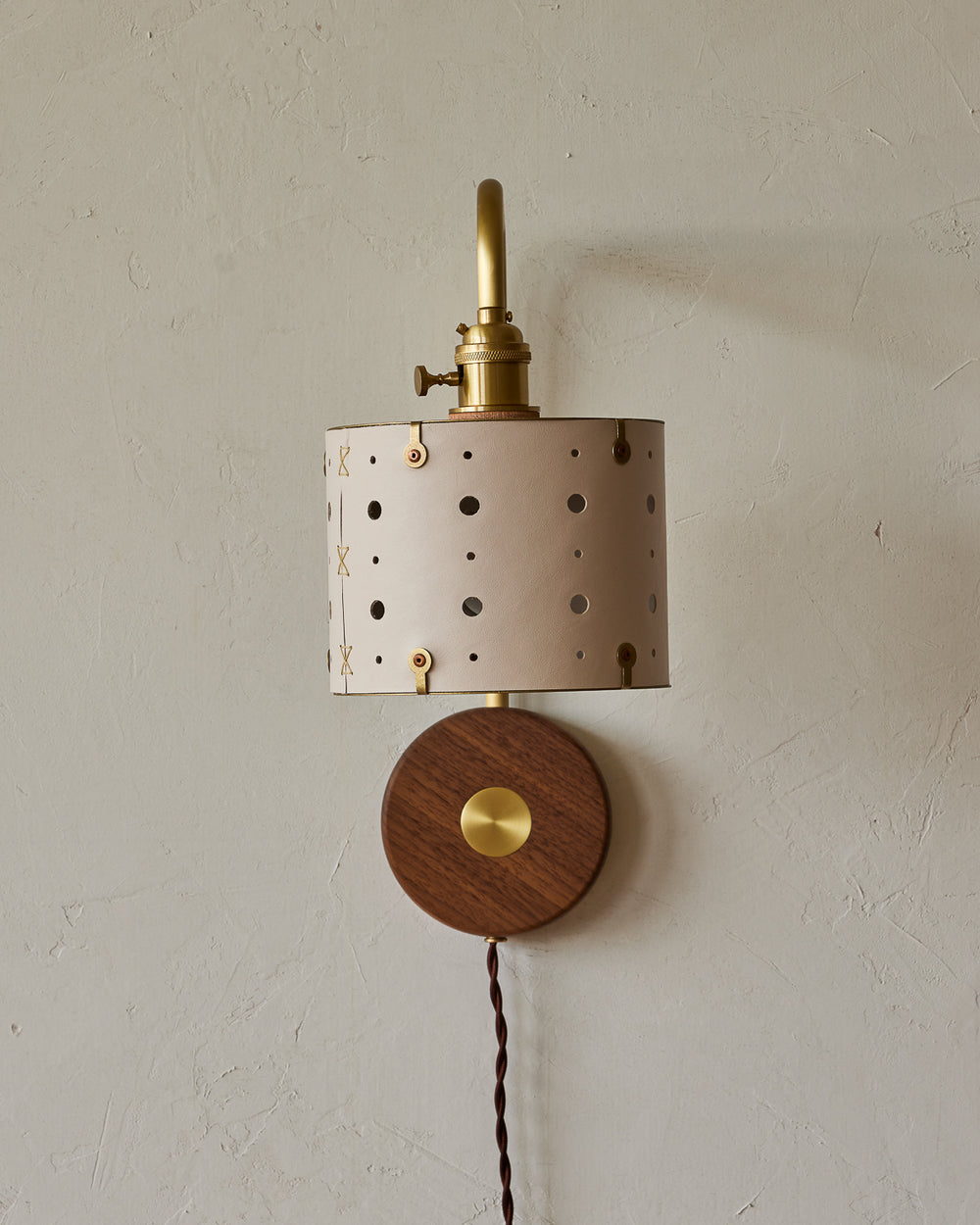 Articulating satin brass plug-in wall sconce with white handstitched shade and walnut backplate #leather-finish_dogwood #wiring_plug-in