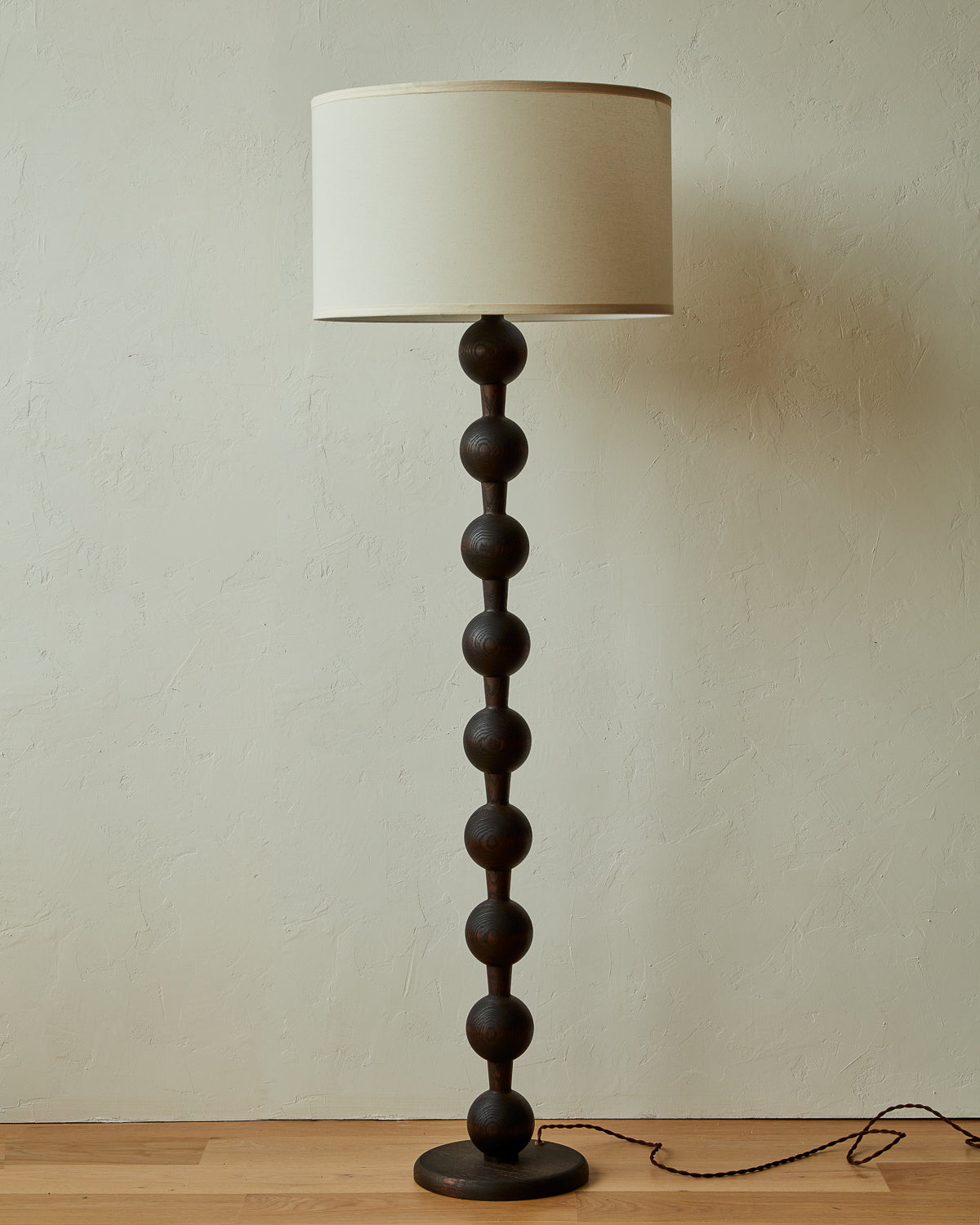 Tall sculptural solid red oak floor lamp with barbell design in dark wash finish with ivory linen drum shade
#color_dark wash red oak
#shade-color_ivory linen