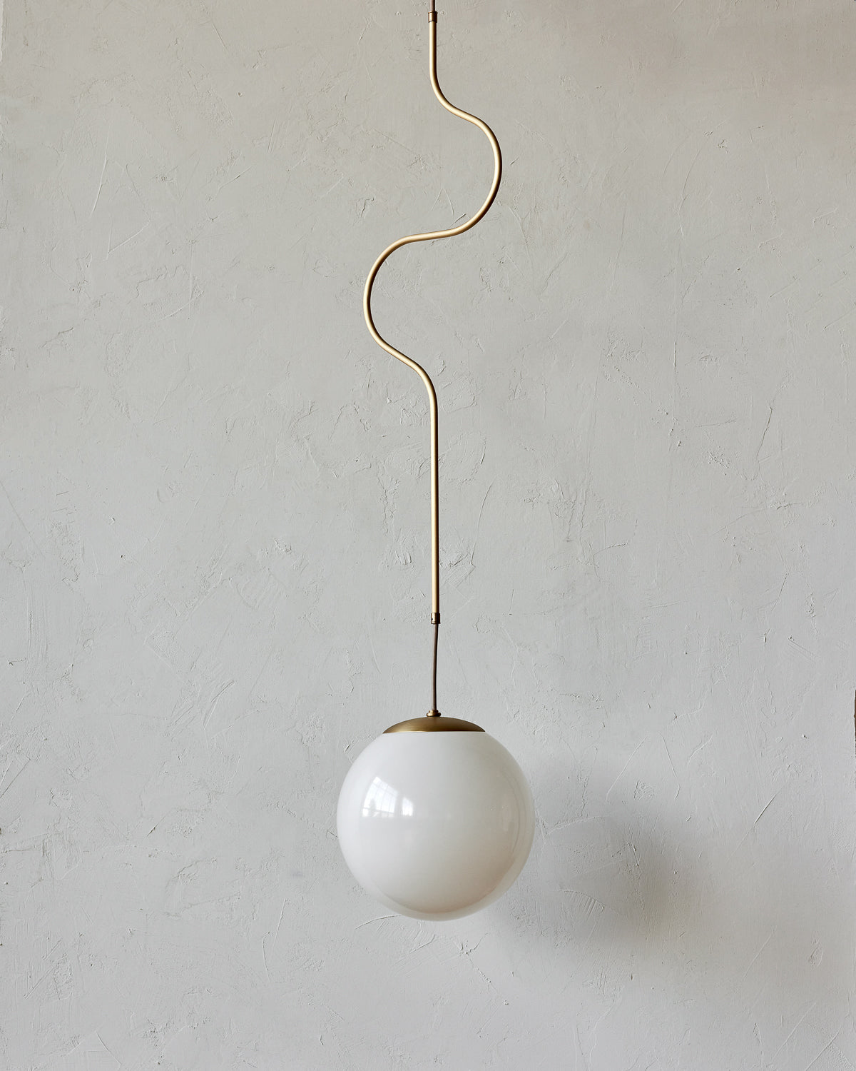 Modern brass globe pendant light with warm satin brass curved body and white milk glass globe #metal-finish_satin brass #size_large