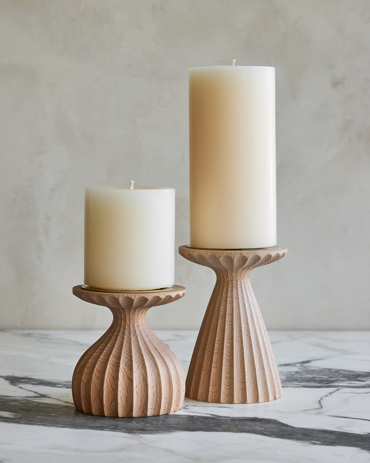 Pair of delicately grooved pillar candle holders in natural maple wood with shell white pillar candles #wood-finish_natural maple