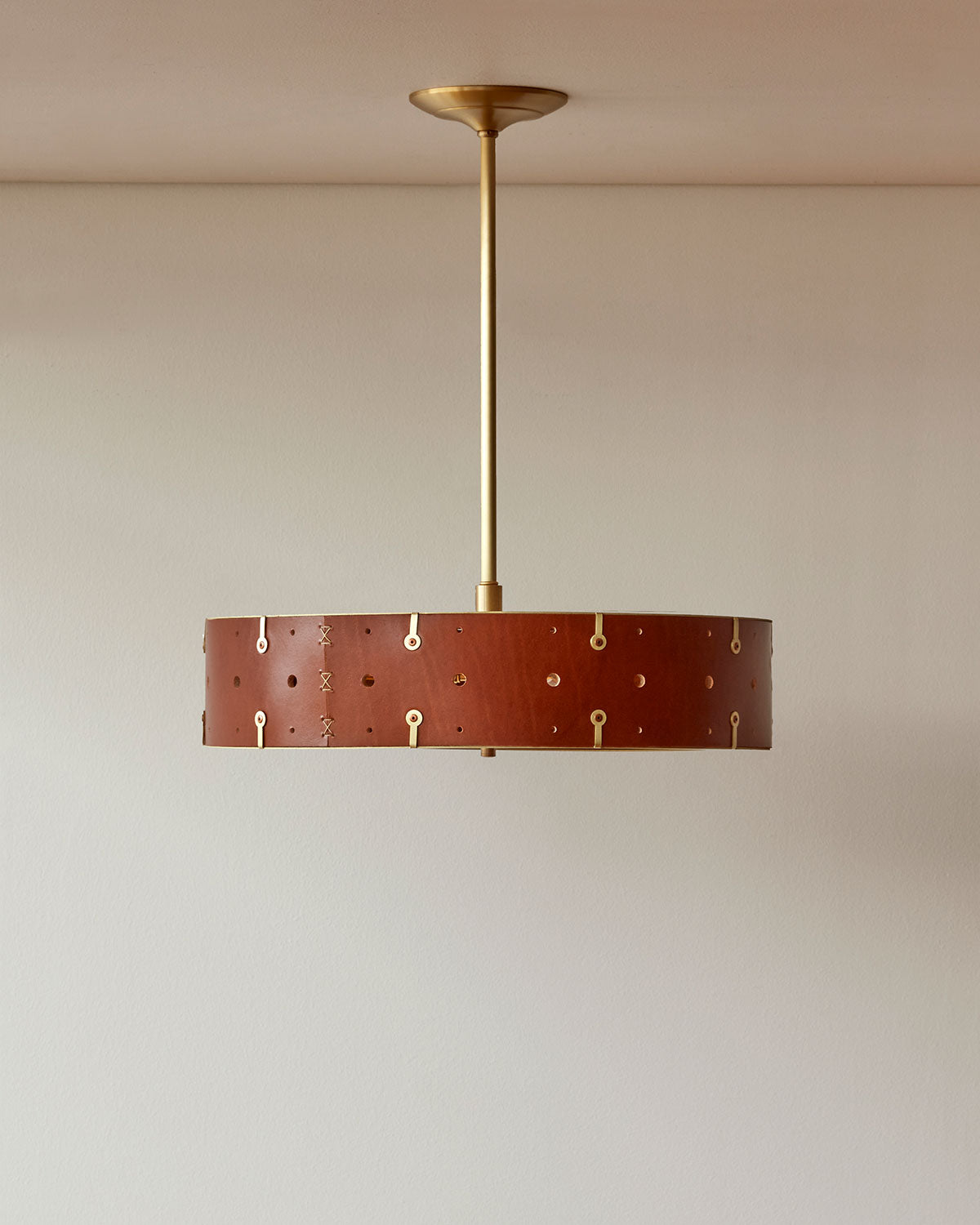 Beautiful satin brass ceiling pendant fixture with handstitched leather drum shade and customizable drop
#leather-color_tan harness #size_18" drum