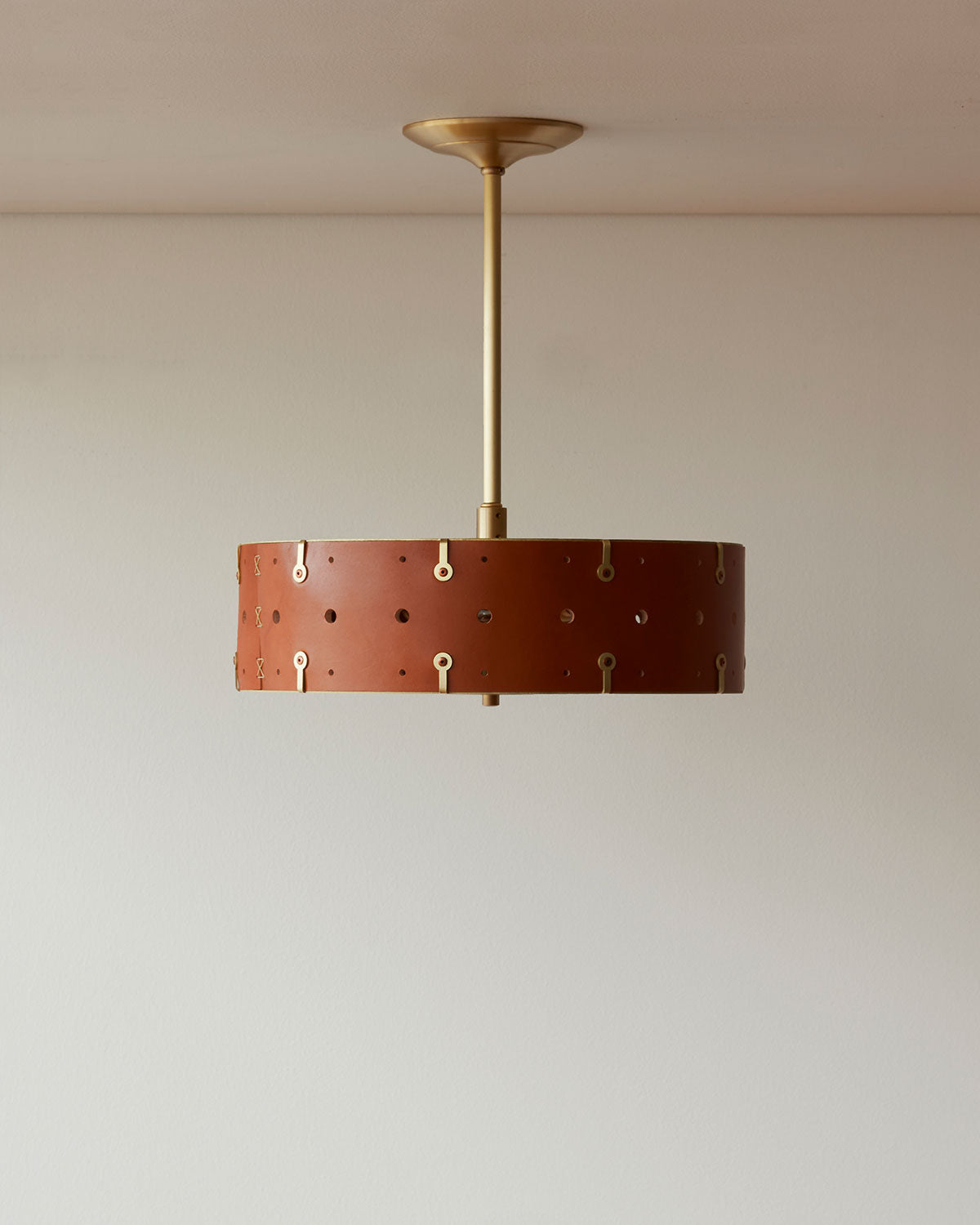 Beautiful satin brass ceiling pendant fixture with handstitched leather drum shade and customizable drop
#leather-color_tan harness #size_14" drum