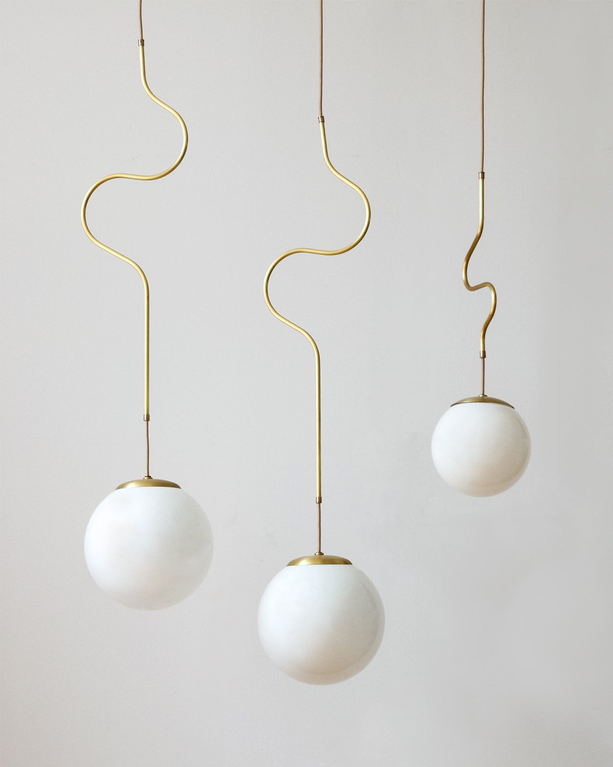 Satin brass Contour ceiling pendant lights made by Lostine in Philadelphia, Pennsylvania.  Satin brass modern lighting design with white glass globe.  Hardwired light fixture.  Simple interior design, made in the USA. #metal-finish_satin brass 