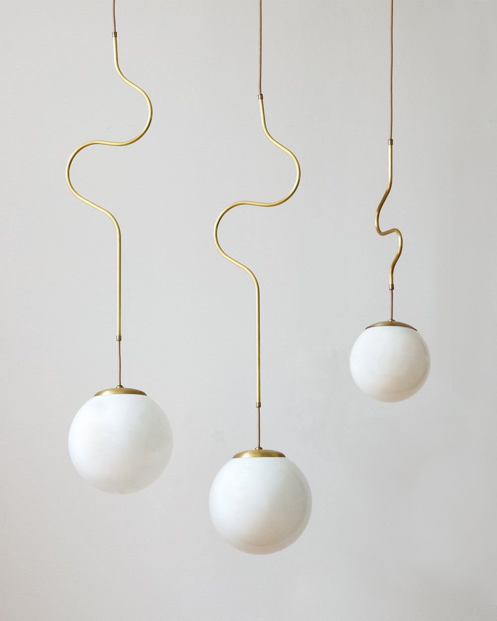 Satin brass Contour ceiling pendant lights made by Lostine in Philadelphia, Pennsylvania.  Satin brass modern lighting design with white glass globe.  Hardwired light fixture.  Simple interior design, made in the USA. #metal-finish_satin brass 